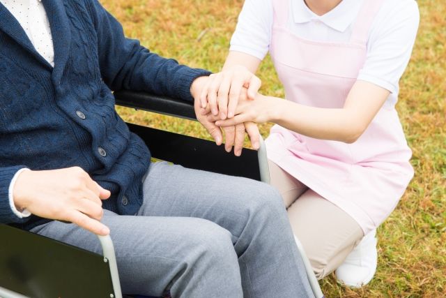 手を添えてしゃがむ女性スタッフ